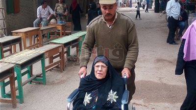 فرد أمن يساعد سيدة مسنة على كرسي متحرك في الشرقية (صور)