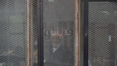 نجل أحد المتهمين في «فض رابعة» يلوح لوالده داخل القفص