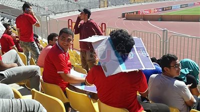 بالصور.. جماهير الأهلي تحتمى من أشعة الشمس في برج العرب بـ «الكراتين»