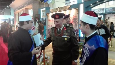 زوار معرض الكتاب يلتقطون صورا تذكارية في جناح القوات المسلحة