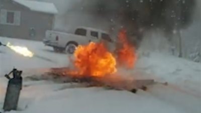 رجل يبتكر قاذفة لهب للتخلص من الجليد أمام منزله (فيديو وصور)