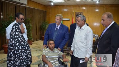 بالصور.. محافظ الإسماعيلية يهدي شابًا معاقًا كرسيًّا متحركًا