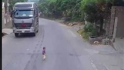 لحظة نجاة طفل صغير من الدهس تحت عجلات شاحنة (فيديو)