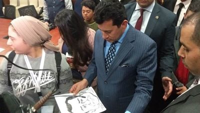 فتاة تهدي وزير الرياضة صورة مرسومة له في معرض الكتاب | صور