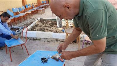 مدير مدرسة بالعريش يصلح المقاعد استعداداً لبدء العام الدراسي |  صور