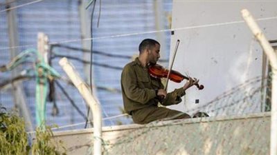 بالتزامن مع المفاوضات .. جندي إسرائيلي يعزف الكمان على الحدود اللبنانية الإسرائيلية | فيديو