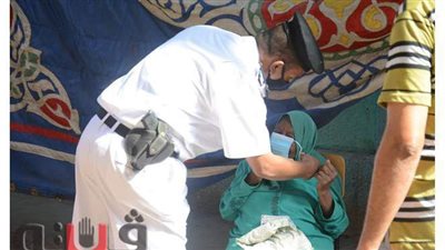 أمين شرطة يساعد مسنة على ارتداء الكمامة الطبية في انتخابات النواب بالهرم | صور