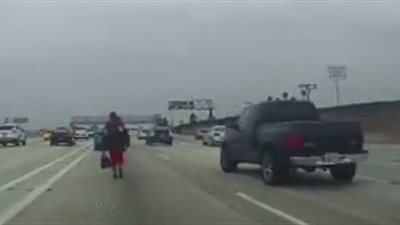 رجل يغامر بحياته وسط طريق سريع للسيارات (فيديو)