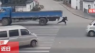 لحظة نجاة سيدة من الدهس تحت عجلات شاحنة (فيديو)