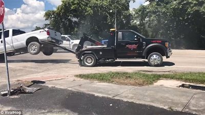 رجل يحاول تخليص شاحنته من رافعة يقع في مأزق (فيديو وصور)