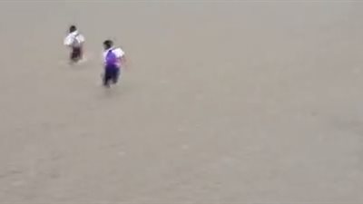 أطفال يعبرون نهرا في الفيضان للوصول لمدرستهم (فيديو)