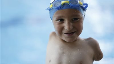 بالصور.. طفل معاق يحصد جوائز بطولات السباحة