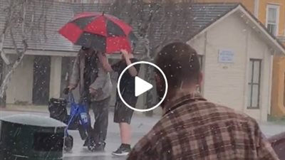 بالفيديو.. موقف شجاع لصبي مع عجوز يسير وسط عاصفة ممطرة