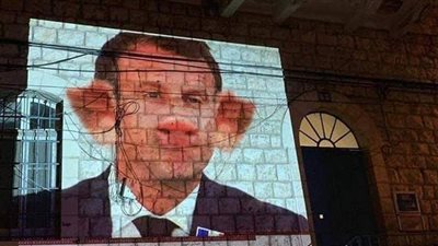 رسوم ضوئية ضد ماكرون على جدران المركز الثقافي الفرنسي في الناصرة | صور