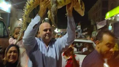 مرشح يحمل تمساحا لتعريف الناخبين برمزه الانتخابي بقليوب