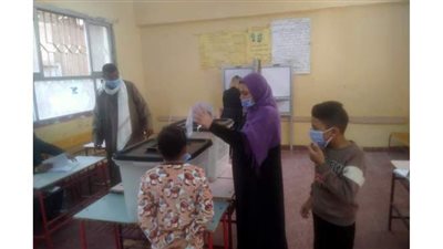 ربة منزل تصطحب نجليها لمشاركتها في انتخابات مجلس النواب بحلوان | صور
