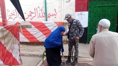 مجندون وأهالى يحملون مسنا على كرسي متحرك عقب الإدلاء بصوته في بدر | فيديو