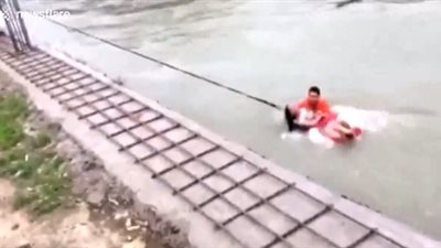 لحظة إنقاذ امرأة جرفتها المياه (فيديو)