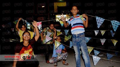 أطفال قنا يتحدون انقطاع الكهرباء ويزينون الشوارع احتفالًا بالشهر الكريم