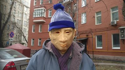 روسي يرتدي قناع «بوتين» أثناء التظاهر أمام الكرملين