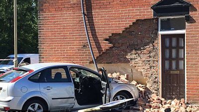 سيارة تقتحم منزلا وتحطم غرفة معيشة (صور)