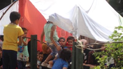 زوار حديقة الحيوان يحتمون من الشمس بالملايات والشجر (صور)