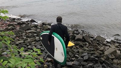 رجل يركب لوح تزلج ويعبر نهرا ليصل إلى اجتماع عمل (فيديو وصور)