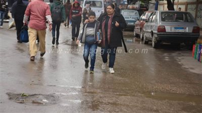 دخول طلاب الابتدائي إلى لجان الامتحانات بالجيزة وسط برك مياه الأمطار | صور