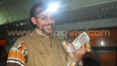 بالصور.. بائع الحلوى يتحدى ظلام قطار المنوفية بـ«كشاف الغطس»