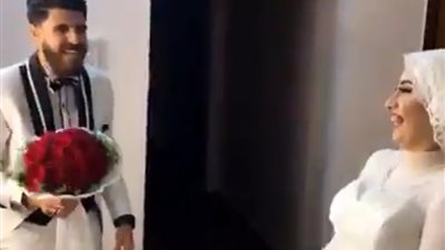 عريس يلقي باقة ورد لمشاهدة عروسه بالفستان الأبيض لأول مرة (فيديو)