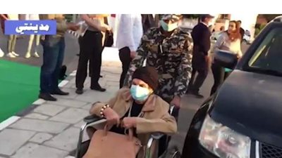 مجند يساعد مسنة على كرسى متحرك للإدلاء بصوتها في مدينتي | فيديو