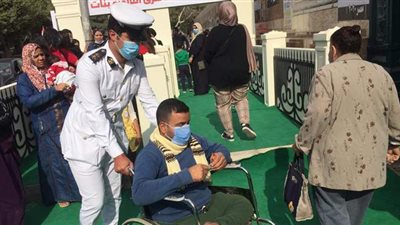 ضابط شرطة يساعد مواطنا يجلس على كرسي متحرك للإدلاء بصوته بانتخابات النواب | صور