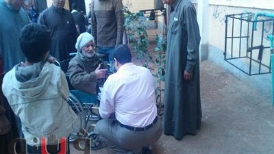 قاضي لجنة وموظفوها يساعدون مسنا على كرسي متحرك بالشرقية | صور
