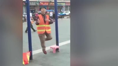 عجوز تعلق نفسها من رقبتها لتأدية عرض بأحد الشوارع (فيديو)