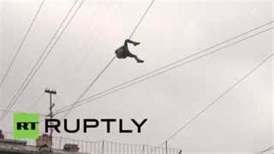 بالفيديو.. متهور يتعلق بأسلاك الهاتف لعبور الشارع بروسيا