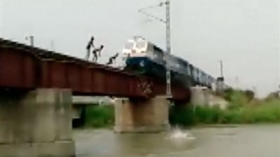 بالفيديو والصور.. صبية يخاطرون بحياتهم بالقفز من أمام قطار مسرع
