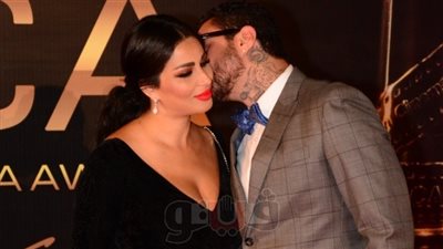 قبلة رومانسية من الفيشاوي لزوجته في حفل جوائز السينما العربية