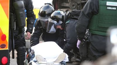 بالصور.. محاولة أعداد كبيرة من الشرطة رفع سيارة من فوق فتاة