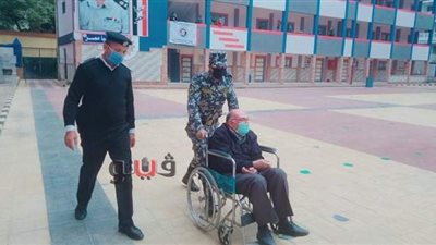 رجال الأمن يساعدون كبار السن بكراسى متحركة بانتخابات مجلس النواب فى الاسكندريه