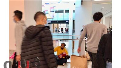 في انتظار والدتها.. أب وابنته يجلسان على الأرض بأحد المولات في 