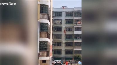لحظة إنقاذ طفلة علقت بنافذة الطابق الرابع (فيديو)