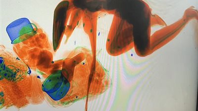 امرأة تمر من جهاز فحص الحقائب بالأشعة (فيديو وصور)