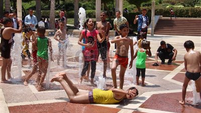أطفال يحولون نافورة حديقة الأزهر إلى حمام سباحة للتغلب على درجات الحرارة (فيديو)