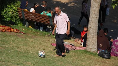 في رابع أيام العيد.. إحدى الأسر تستمتع بلعب الكرة بحديقة الأزهر (صور)