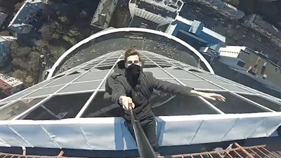 شاب يخاطر بحياته بأعلى مبنى في كييف (فيديو وصور)