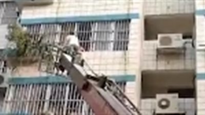 لحظة إنقاذ فتاة علقت بين قضبان الأمان لنافذة بالطابق الرابع (فيديو)