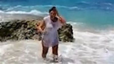 الأمواج تفسد على امرأة التقاط صورة على الشاطئ (فيديو وصور)