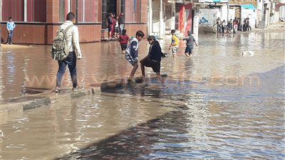 بالصور.. أطفال العريش يستغلون مياه الأمطار للهو