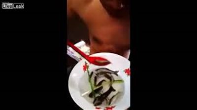 مشهد صادم لرجل يأكل طبقا من الأسماك الحية (فيديو)