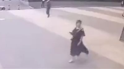 لحظة سقوط لوحة إعلانات من مبنى عال على رأس امرأة (فيديو)